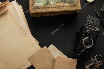 Vecchia fotocamera su tavolo e scatti stampati nello studio